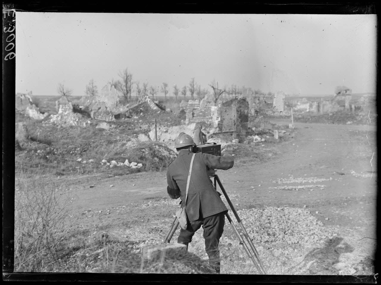 Un caméraman de la Section photographique et cinématographique de l'armée (SPCA) filme les ruines de Souain.