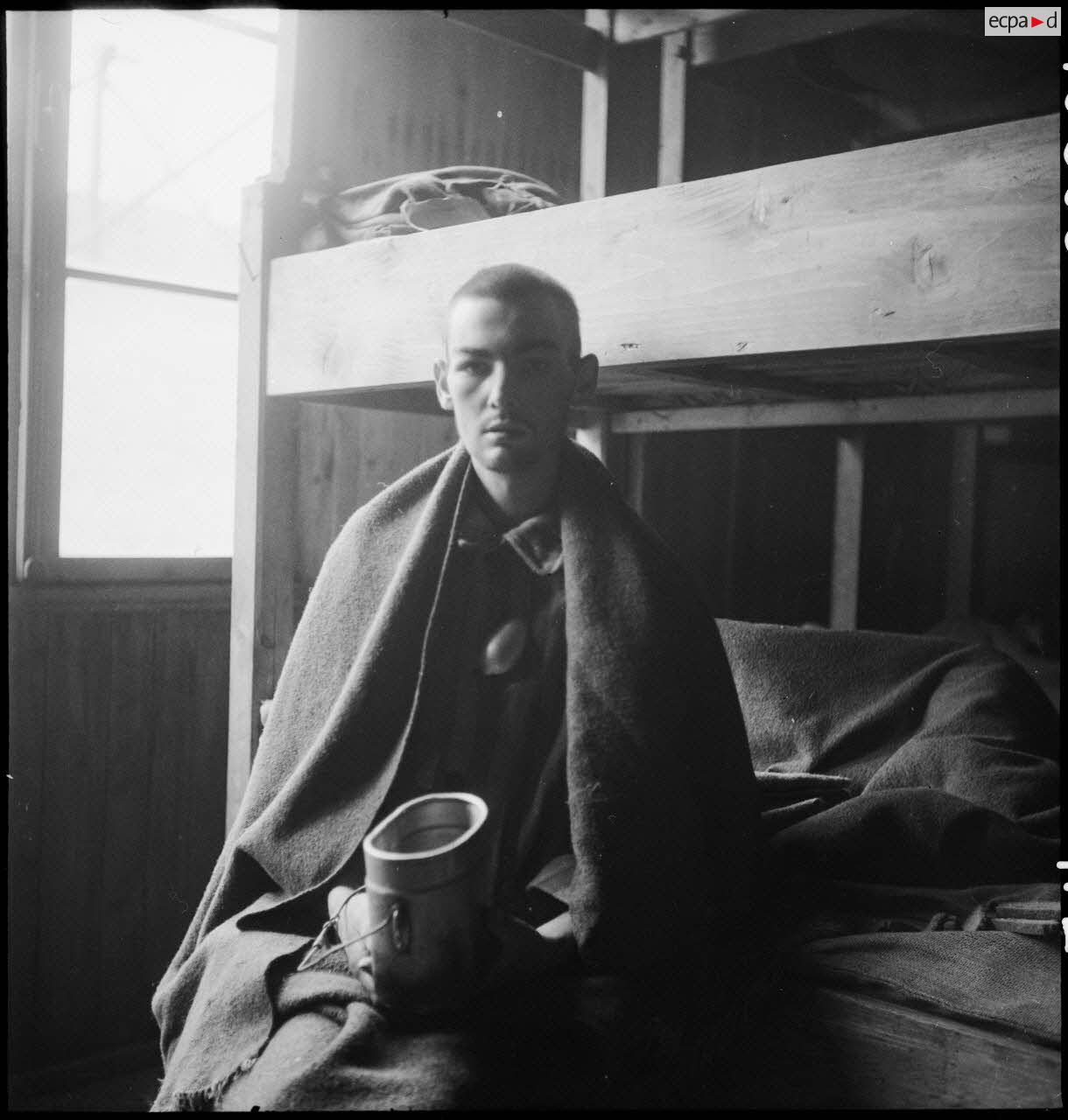 Portrait d'un déporté dans un baraquement du camp de Vaihingen récemment libéré.